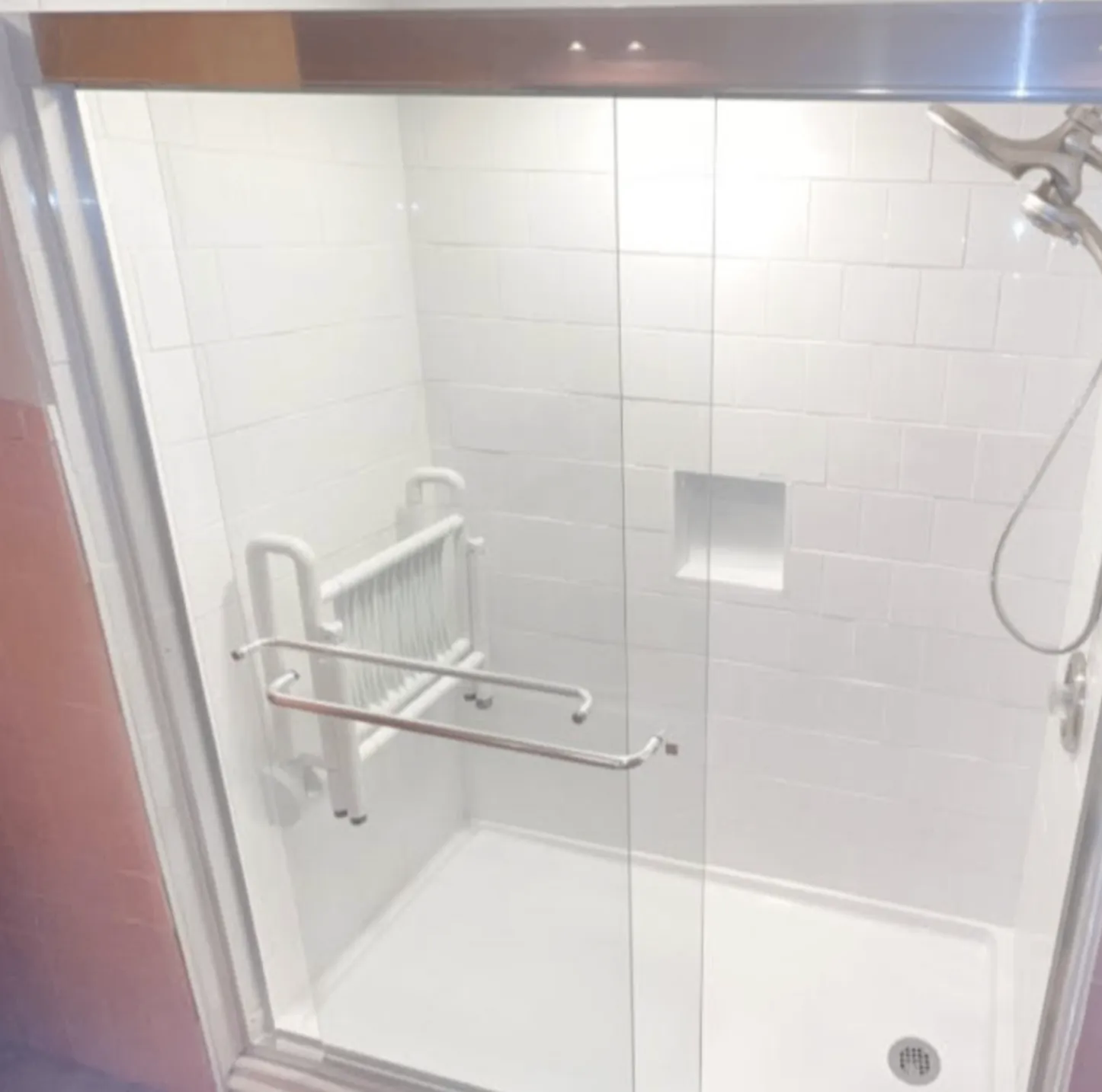 Updated tub and shower with white subway tile, recessed niche, glass panel, and chrome fixtures