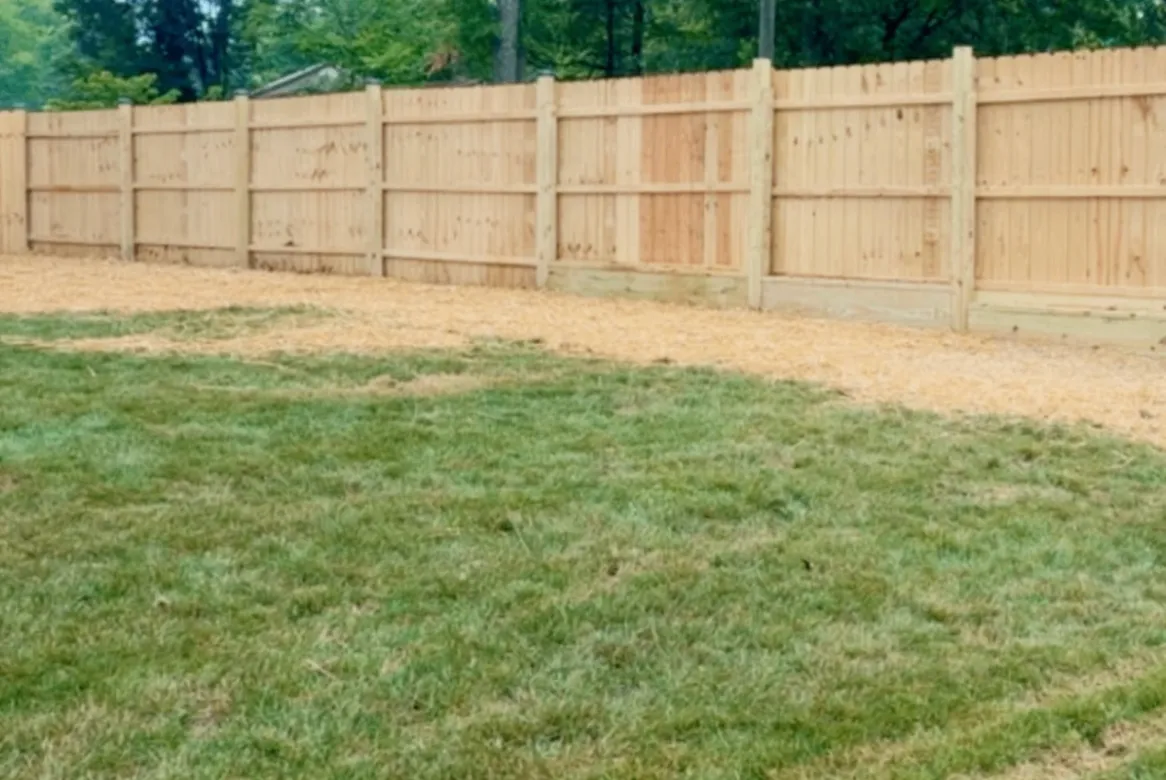 New cedar fence with horizontal rails and a fresh mulch bed underneath